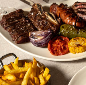 2 platos de parrilla bien servidos, incluyendo vino.